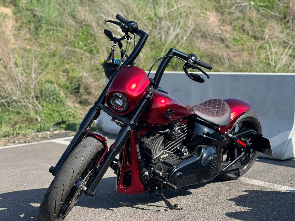 A stunning red Harley Davidson motorcycle parked outdoors, showcasing modern design and style.